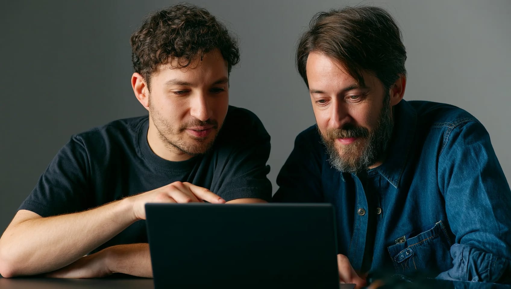 Two developers pair programming against a shared data model on side-by-side monitors